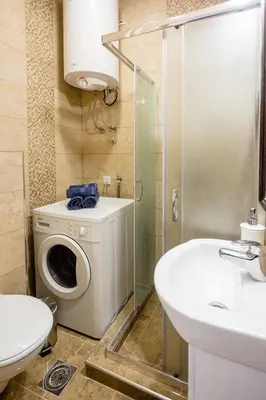 a bathroom with a toilet sink and a washing machine at The Duke Apartment in Belgrade