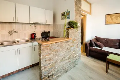 a kitchen with white cabinets and a brick wall at The Duke Apartment in Belgrade