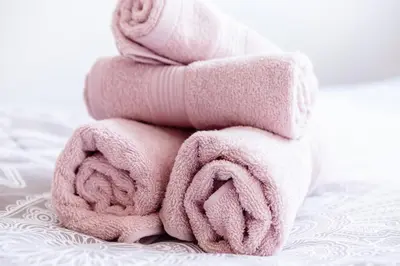 a stack of pink towels sitting on a bed at The Duke Apartment in Belgrade