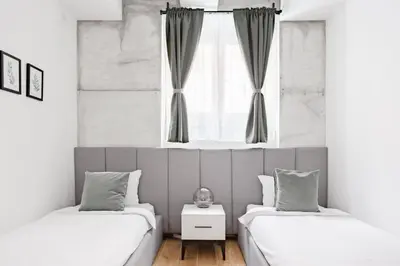 two beds in a room with a window at HostGost Selected Suites - Molerova 9 in Belgrade