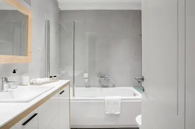 a white bathroom with a tub and a sink at HostGost Selected Suites - Molerova 9 in Belgrade