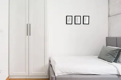 a bedroom with white cabinets and a bed with white sheets at HostGost Selected Suites - Molerova 9 in Belgrade