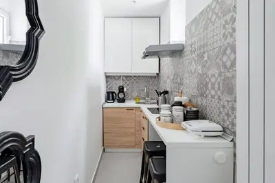 a small kitchen with white cabinets and a counter at HostGost Selected Suites - Molerova 9 in Belgrade