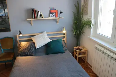 a bedroom with a bed and a shelf on the wall at Atelier 22 in Belgrade