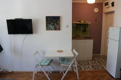 a kitchen with a table and two chairs and a refrigerator at Atelier 22 in Belgrade