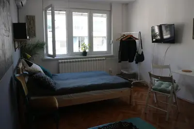 a bedroom with a bed and a window and a chair at Atelier 22 in Belgrade