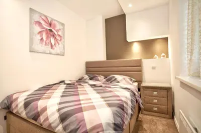 a small bedroom with a bed and a night stand at HostGost Selected Suites - Skadarlija Square in Belgrade