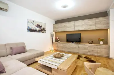 a living room with a couch and a tv at HostGost Selected Suites - Skadarlija Square in Belgrade