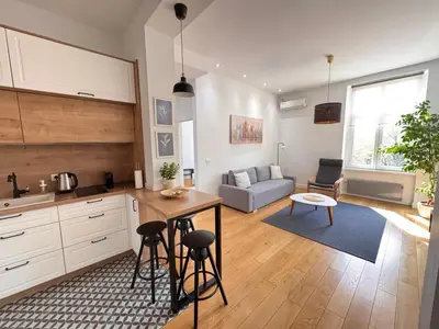 a kitchen and living room with a table and a couch at Downtown Apartment in Belgrade