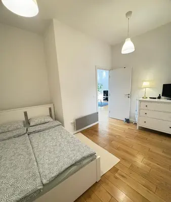 a bedroom with a bed and a dresser and a television at Downtown Apartment in Belgrade