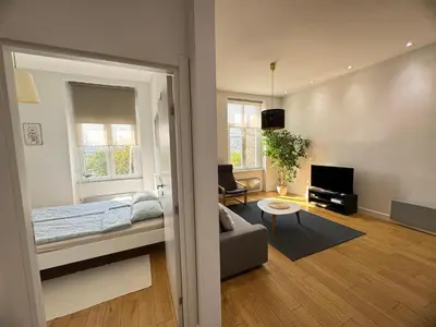 a bedroom with a bed and a living room at Downtown Apartment in Belgrade