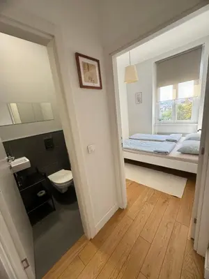 a bedroom with a bed and a toilet and a window at Downtown Apartment in Belgrade