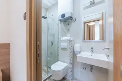 a bathroom with a shower and a toilet and a sink at M House Belgrade Residence in Belgrade