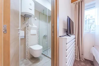 a bathroom with a toilet and a television in it at M House Belgrade Residence in Belgrade