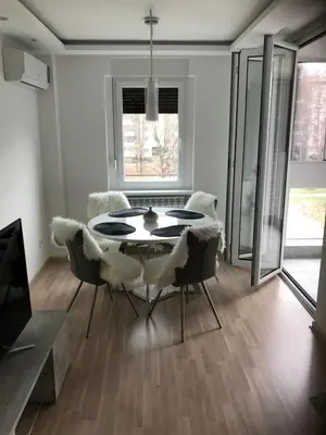 a dining room with a table and chairs at Apartman Oslo in Belgrade