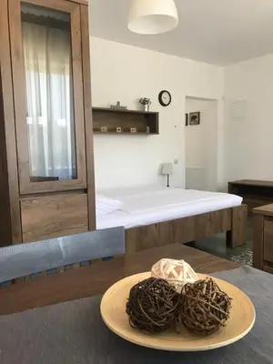 a plate on a table with a bed in a room at Grocka Apartmani & rooms in Grocka