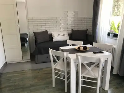 a living room with a table and chairs and a couch at Grocka Apartmani & rooms in Grocka
