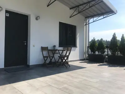 a patio with chairs and a table and a door at Grocka Apartmani & rooms in Grocka