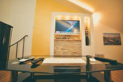 a glass table with two remote controls and a television at Apartman Las Vegas in Belgrade