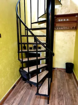 a spiral staircase in a room with yellow walls at Apartman Las Vegas in Belgrade