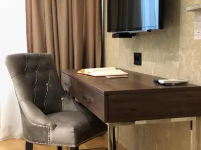 a chair sitting next to a desk with a television at Aria Royal apartment in Belgrade