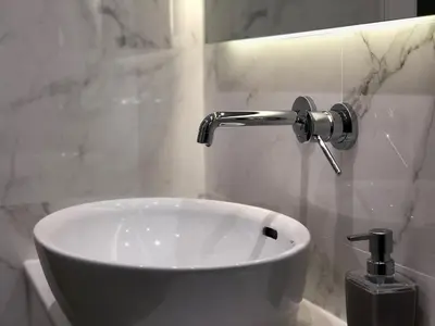 a white sink in a bathroom with a faucet at Aria Royal apartment in Belgrade