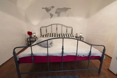 a bedroom with a metal bed with a map on the wall at Dolce Casa in Belgrade