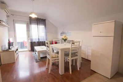 a kitchen with a white table and chairs and a refrigerator at Dolce Casa in Belgrade
