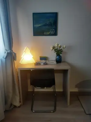 a desk with a lamp and a vase of flowers on it at Victor Residence in Belgrade