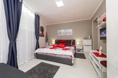 a bedroom with a bed with red pillows on it at Apartment Romanov in Belgrade
