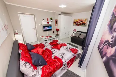 a bedroom with a large bed with red pillows at Apartment Romanov in Belgrade