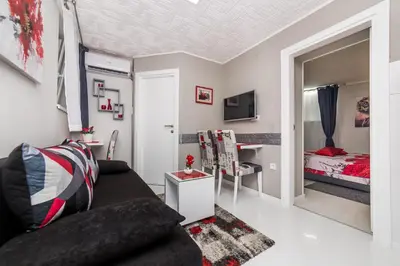 a living room with a couch and a bedroom at Apartment Romanov in Belgrade