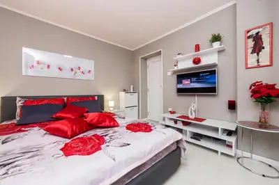 a bedroom with a large bed with red pillows at Apartment Romanov in Belgrade
