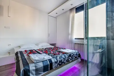 a bedroom with a bed and a glass wall at Luxury Boutique City Center Apartments in Belgrade