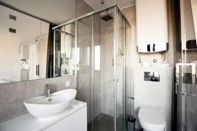 a bathroom with a sink and a glass shower at Luxury Boutique City Center Apartments in Belgrade