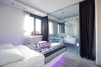 a bedroom with a large bed and a bathroom at Luxury Boutique City Center Apartments in Belgrade