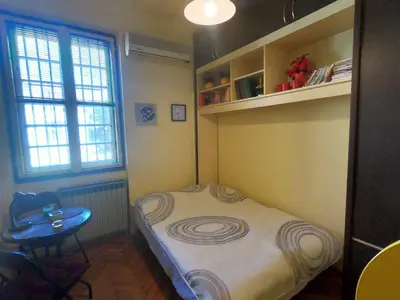 a small room with a small bed and a table at Aprtman Sonja 2 in Belgrade