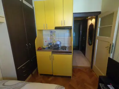 a small kitchen with yellow cabinets in a room at Aprtman Sonja 2 in Belgrade