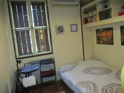 a small bedroom with a bed and a window at Aprtman Sonja 2 in Belgrade