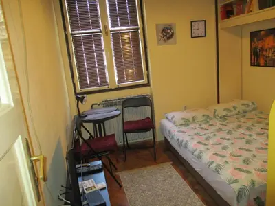 a bedroom with a bed and a table and a window at Aprtman Sonja 2 in Belgrade