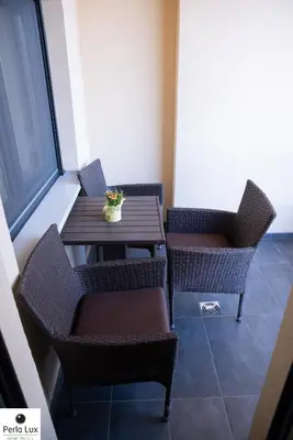 a table and chairs in a room with a window at Perla Lux Apartments in Arandjelovac