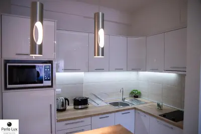 a white kitchen with a sink and a microwave at Perla Lux Apartments in Arandjelovac