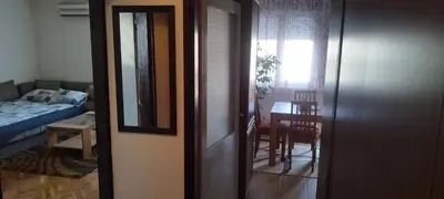 a room with a door and a room with a table at Apartman LENA in Arandjelovac