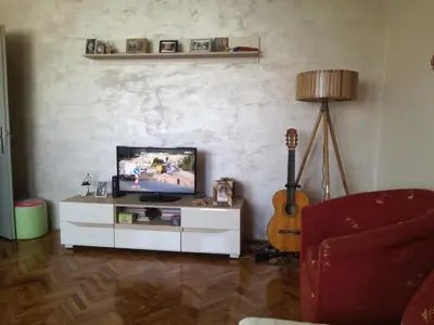 a living room with a tv and a guitar at Apartman LENA in Arandjelovac