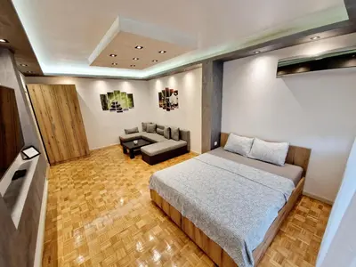 a bedroom with a bed and a couch at Apartmani Paku in Belgrade