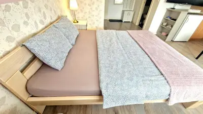 a bed with a blanket on top of it at Apartmani Paku in Belgrade