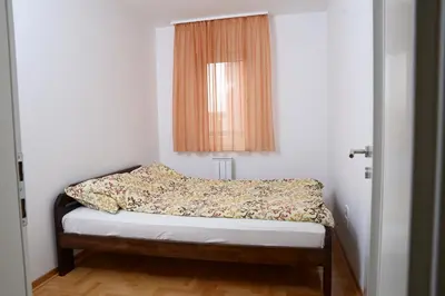 a small bedroom with a bed with a window at Zap apartman in Belgrade