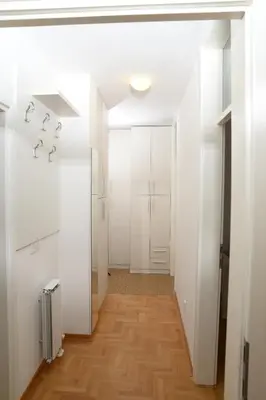 a hallway with white walls and wood floors at Zap apartman in Belgrade