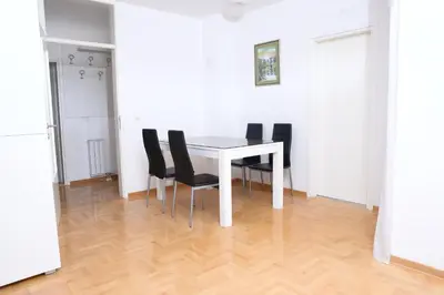 a dining room with a white table and black chairs at Zap apartman in Belgrade