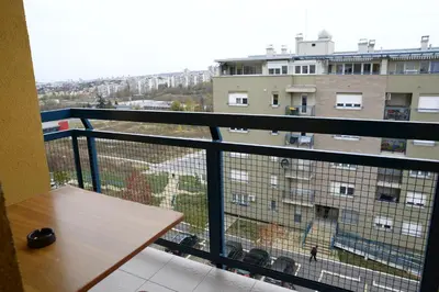 a balcony with a table and a view of a building at Zap apartman in Belgrade